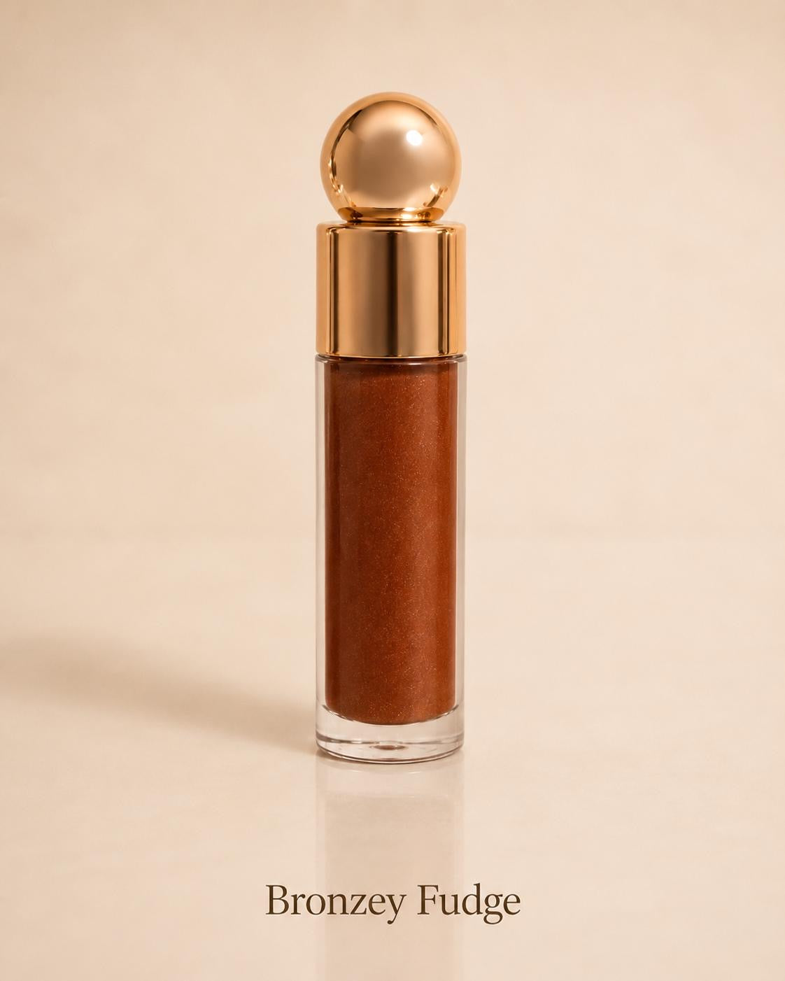 Bronzey Fudge shimmering bronze lip gloss on a warm beige background