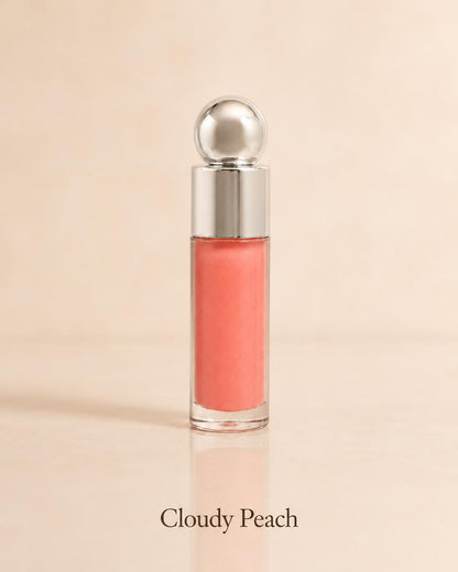 Cloudy Peach lip gloss in a coral-peach shade on a warm beige background